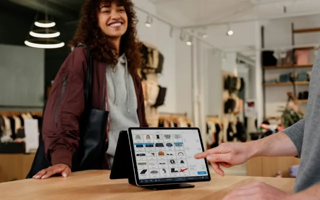 A shop counter with a tablet point of sale and a customer paying
